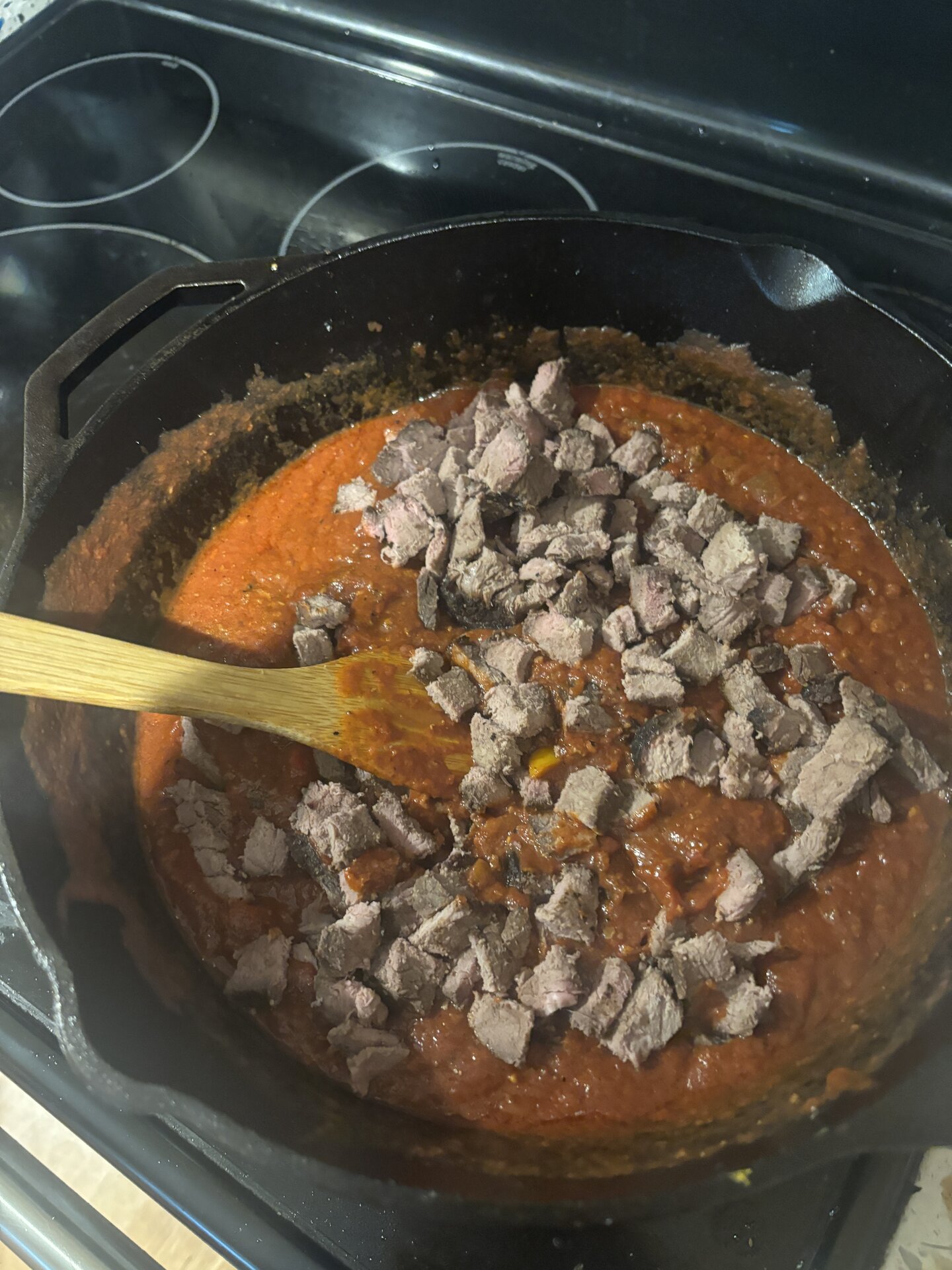 Diced leftover London broil added on top of the red sauce