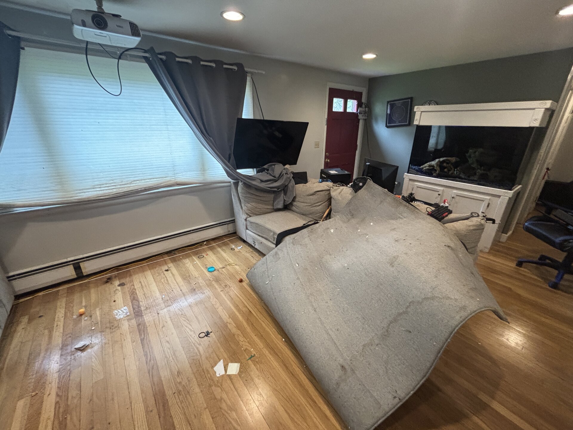 box spring leaned against wall, sectional disassembled, broom out