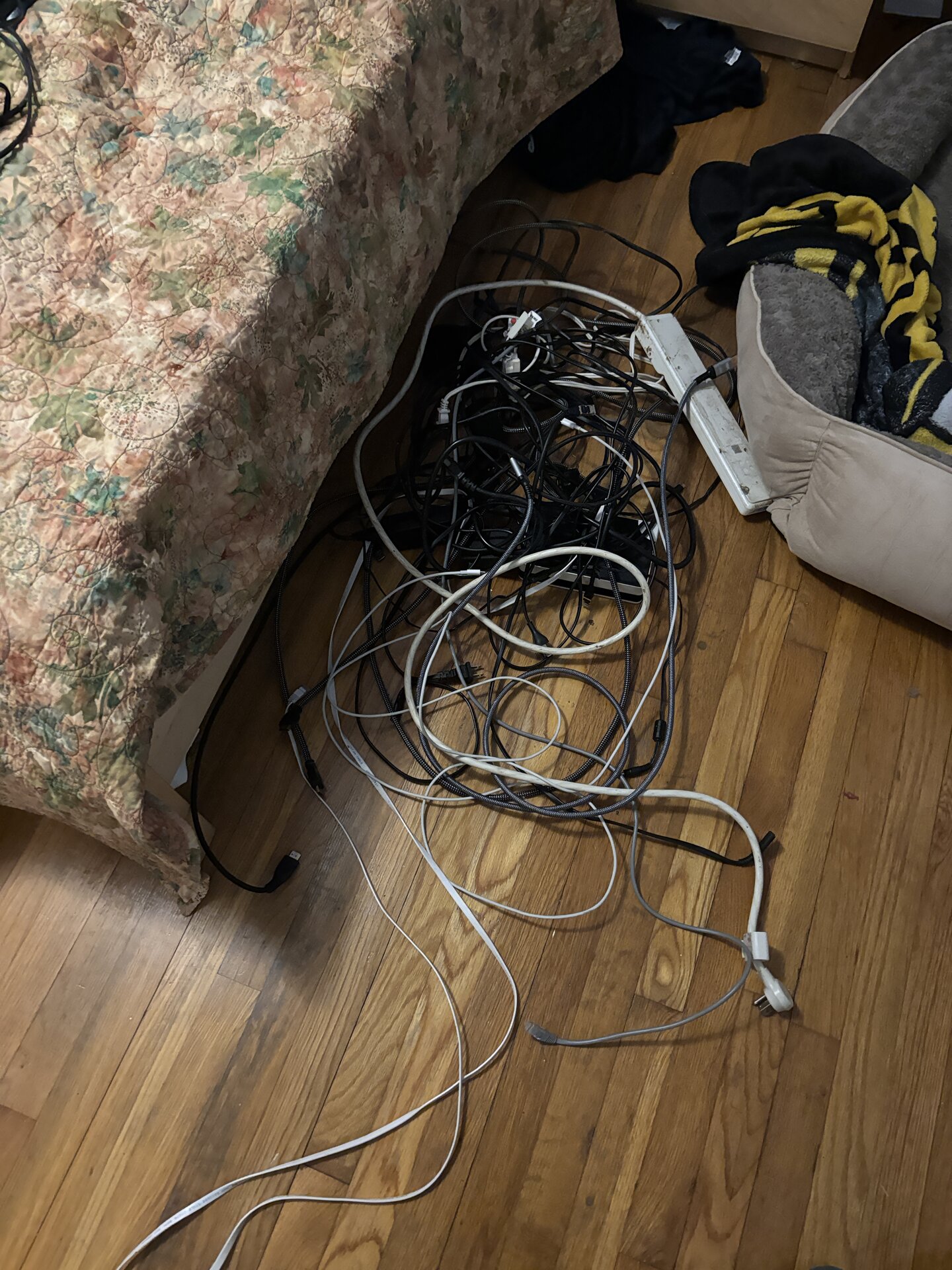 tangle of cables and a power strip on hardwood floor